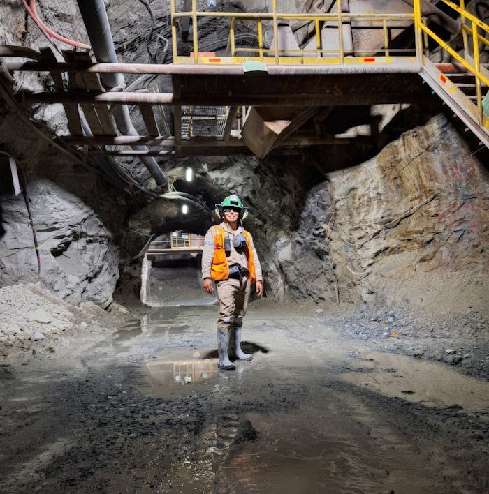gallery-2 Engineer standing in an illuminated underground mine tunnel, showcasing mining safety gear and modern infrastructure.